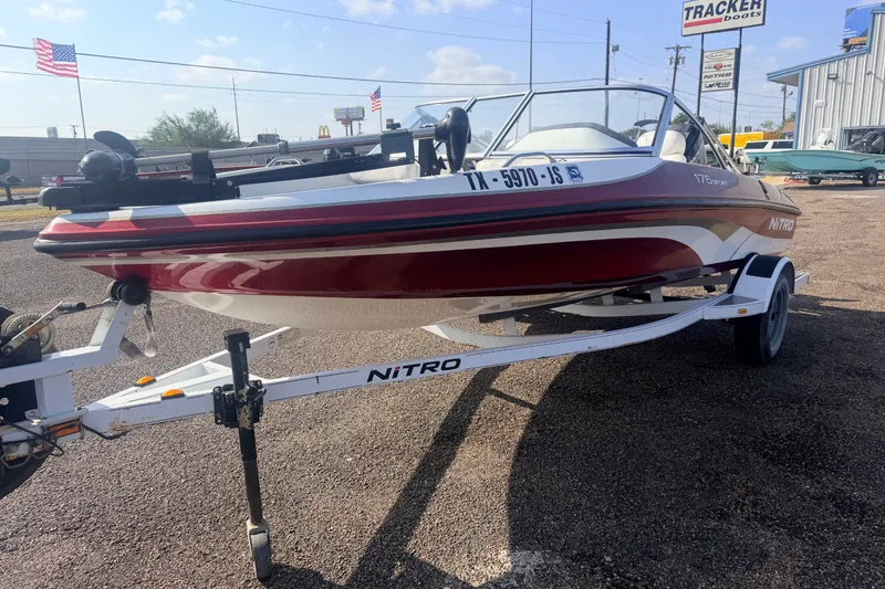 Slide: The Image of 2002 Nitro 175 Sport boat on trailer, parked outdoors with dealership signs in background. - 4