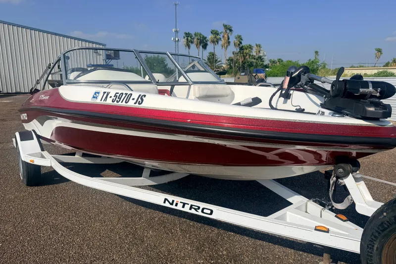 Slide: The Image of 2002 Nitro 175 Sport boat on trailer, red and white, parked outdoors. - 3