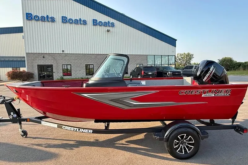 The Image of 2027 Crestliner 1650 Kodiak WT boat in red, parked outside a dealership. - 0