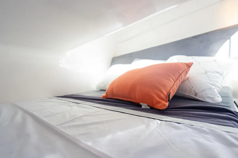 Slide: The Image of Modern bed with orange and white pillows in a Hanover 305, 2026 model. - 10