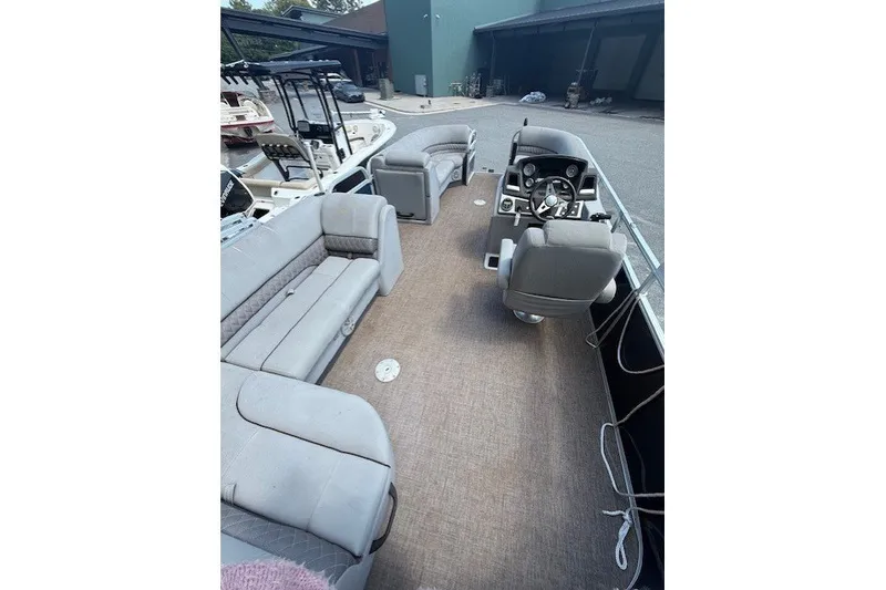 Slide: The Image of The image shows the interior of a Ranger Reata 200C pontoon boat with gray seating and a helm. - 8