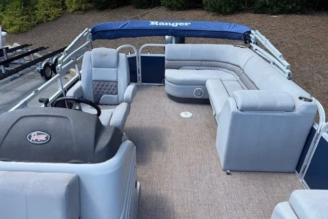 Slide: The Image of The image shows a 2019 Ranger Reata 200C pontoon boat with gray upholstery and a blue sunshade. - 5