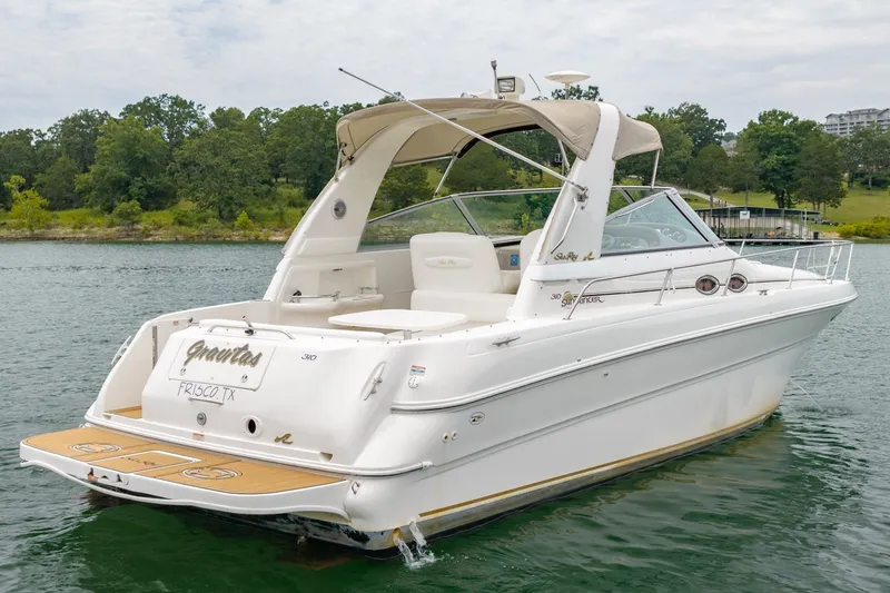 Slide: The Image of 2001 Sea Ray Sundancer 310 boat on a lake, featuring sleek design and spacious deck. - 5