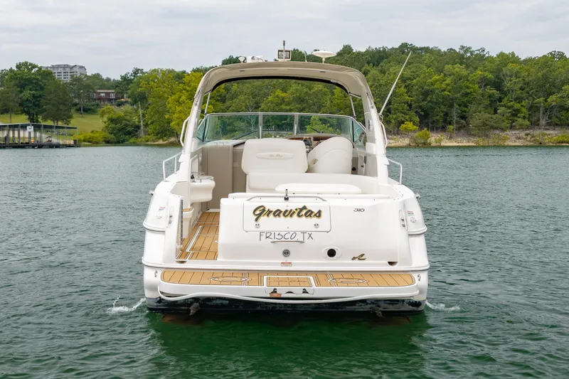 Slide: The Image of 2001 Sea Ray Sundancer 310 boat on a lake, rear view with lush green shoreline. - 3