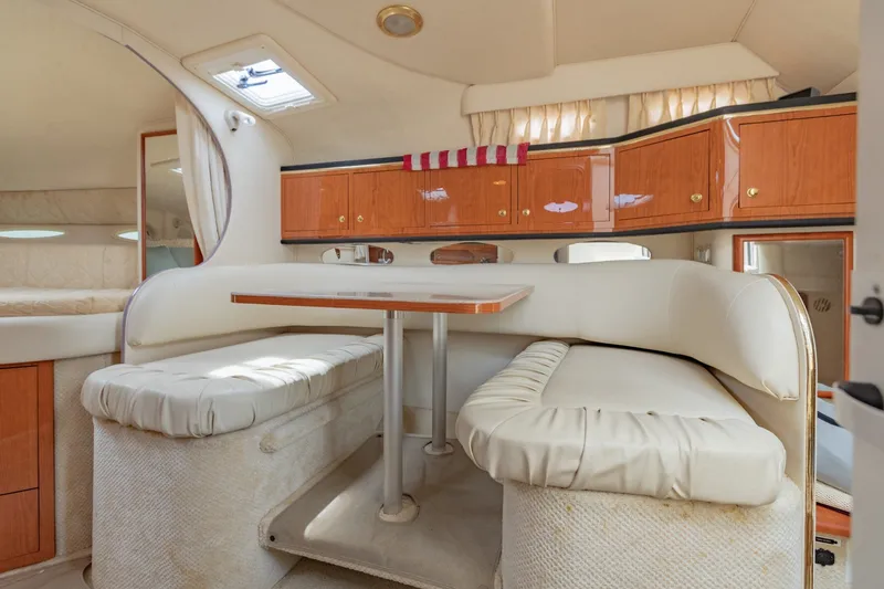 Slide: The Image of Interior of 2001 Sea Ray Sundancer 310, featuring a cozy dining area with wooden cabinets. - 32