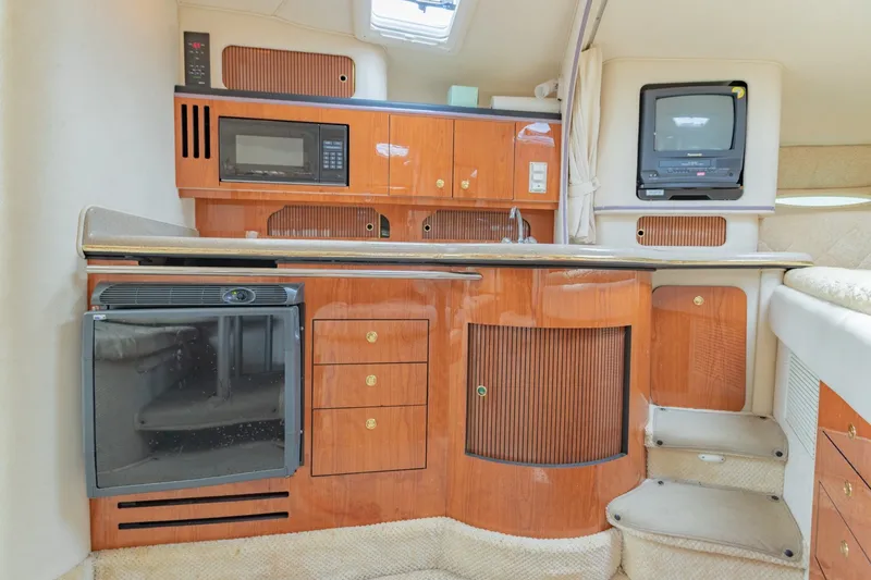 Slide: The Image of 2001 Sea Ray Sundancer 310 cabin interior with kitchenette, microwave, and TV. - 25