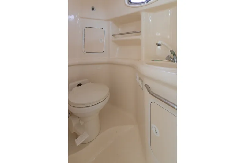 Slide: The Image of 2001 Sea Ray Sundancer 310 bathroom with toilet, sink, and storage compartments. - 29