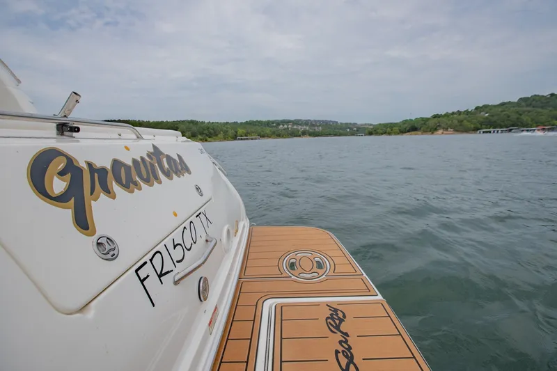 Slide: The Image of 2001 Sea Ray Sundancer 310 boat on water, rear view with "Gravitas" name. - 12