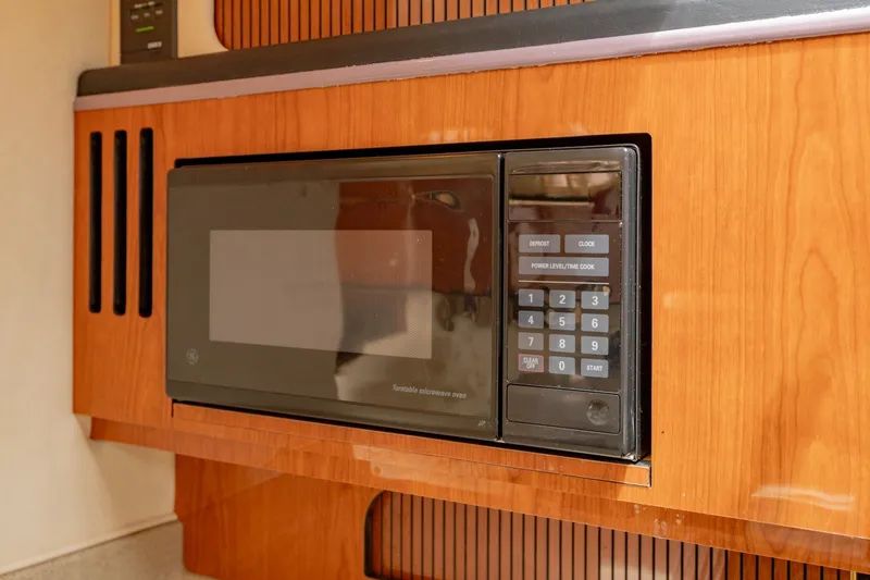Slide: The Image of Microwave in 2001 Sea Ray Sundancer 310 yacht kitchen, featuring wood cabinetry. - 27
