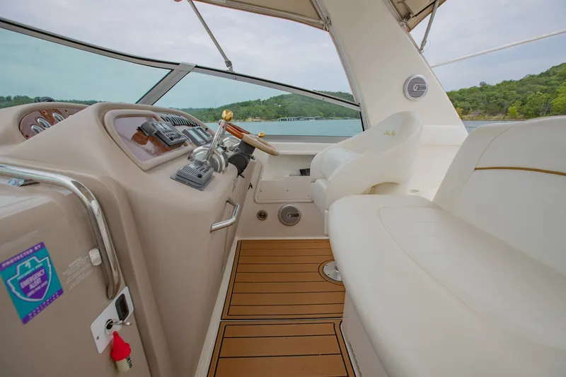 Slide: The Image of Cockpit of 2001 Sea Ray Sundancer 310 with steering wheel and seating, overlooking water. - 13