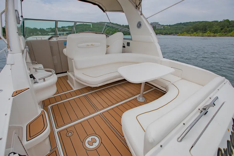 Slide: The Image of 2001 Sea Ray Sundancer 310 boat interior with white seating and wooden deck. - 11