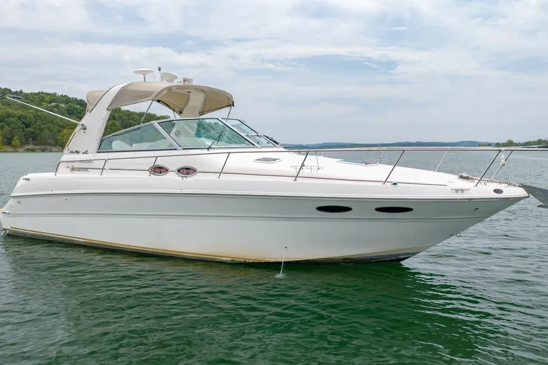 Slide: The Image of 2001 Sea Ray Sundancer 310 boat on calm water, showcasing sleek design and white exterior. - 7