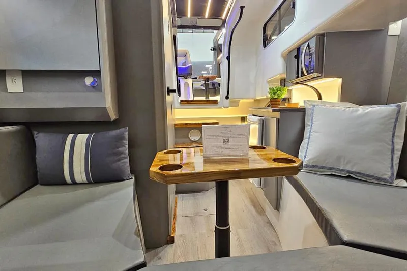 Slide: The Image of Modern interior of 2026 Hanover 327 RV with cozy seating and wooden table. - 14