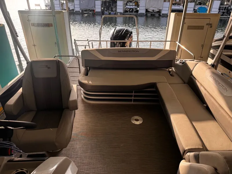 Slide: The Image of Interior of a 2023 Bennington 23SXSB pontoon boat with beige seating and a view of the water. - 7