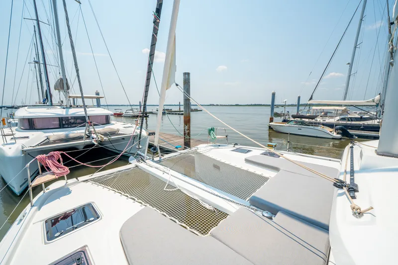 Slide: The Image of 2026 Lagoon 38 catamaran docked at marina on a sunny day. - 16