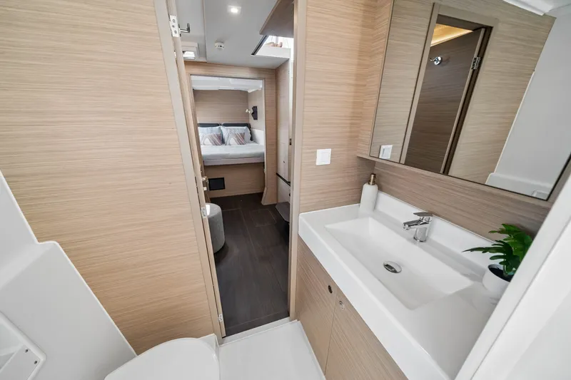 Slide: The Image of Modern bathroom and bedroom interior of 2026 Lagoon 38 yacht, featuring sleek design and wood accents. - 70