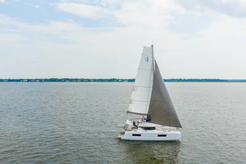 Slide: The Image of Sailing Lagoon 38 catamaran on open water, 2026 model, under clear skies. - 2