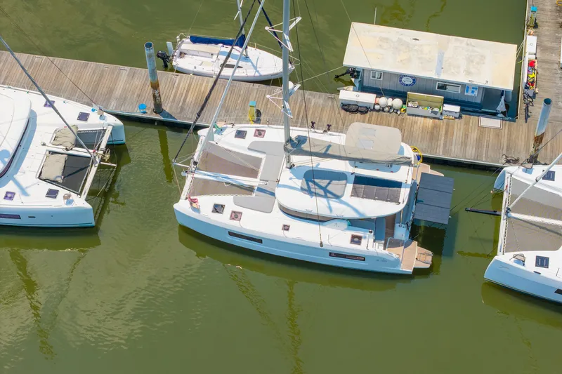Slide: The Image of Aerial view of a 2026 Lagoon 38 catamaran docked at a marina. - 91