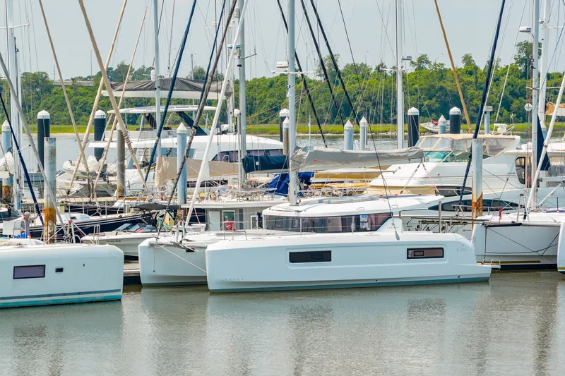 Slide: The Image of 2026 Lagoon 38 catamaran docked in a marina, surrounded by other boats. - 87