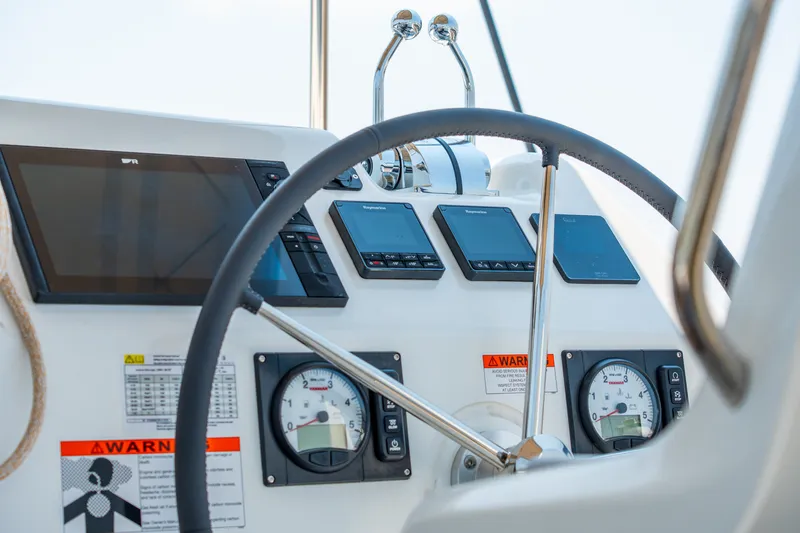 Slide: The Image of Helm of 2026 Lagoon 38 catamaran with modern navigation instruments and steering wheel. - 32