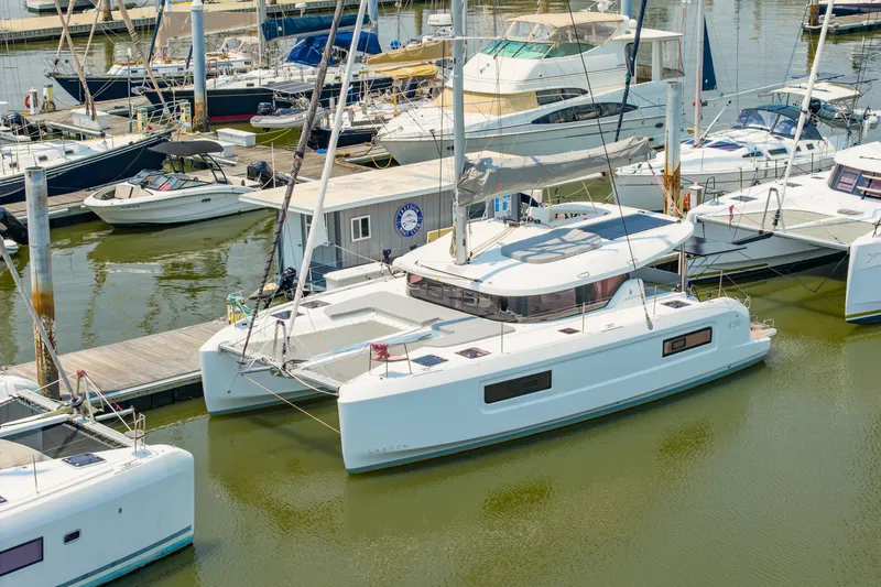 Slide: The Image of Modern 2026 Lagoon 38 catamaran docked at marina with other boats. - 86
