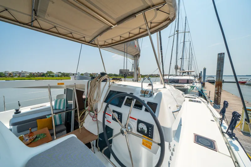 Slide: The Image of Modern 2026 Lagoon 38 catamaran docked, featuring spacious cockpit and steering wheel. - 36