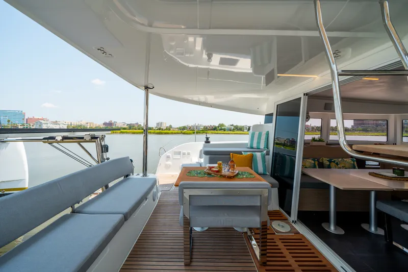 Slide: The Image of Luxurious 2026 Lagoon 38 yacht interior with elegant seating and dining area, overlooking serene waterfront. - 39