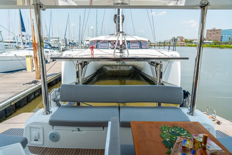 Slide: The Image of 2026 Lagoon 38 catamaran docked at marina, featuring spacious seating and table with snacks. - 40
