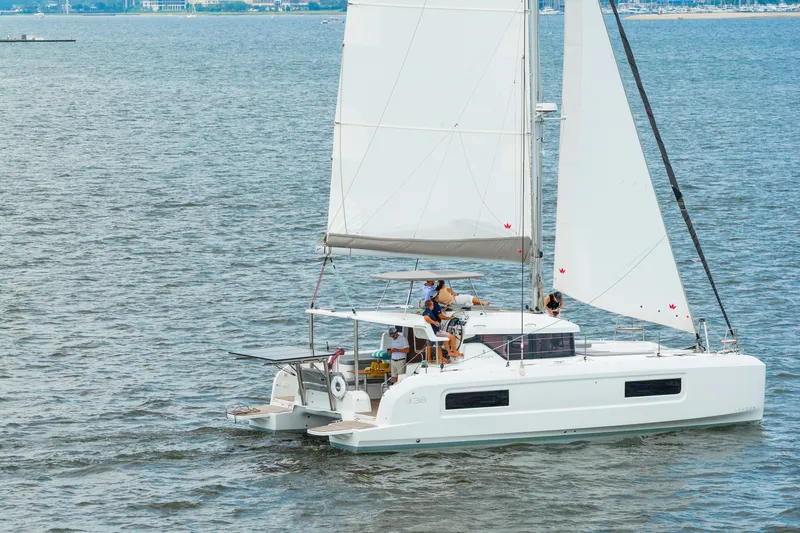 Slide: The Image of 2026 Lagoon 38 catamaran sailing on open water with passengers onboard. - 102