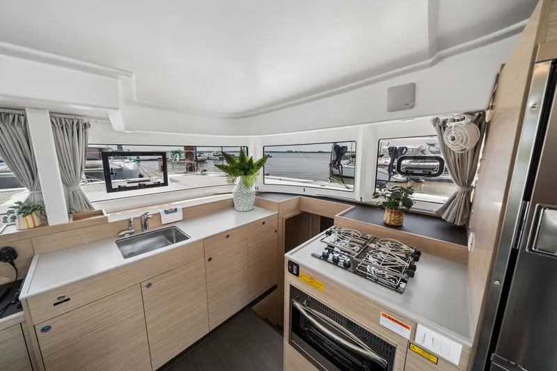 Slide: The Image of Modern kitchen interior of 2026 Lagoon 38 yacht with stove, sink, and scenic windows. - 48