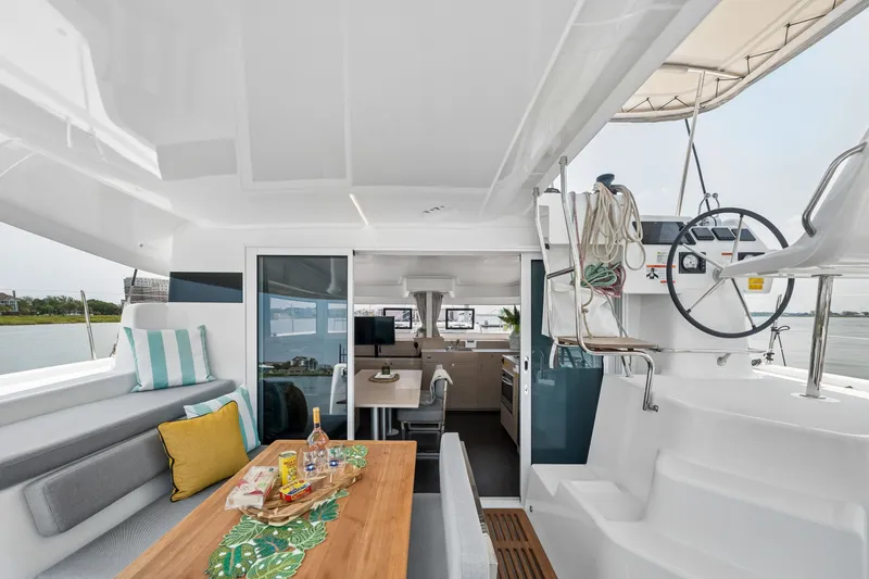 Slide: The Image of Modern Lagoon 38 catamaran interior, featuring a dining area and helm, 2026 model. - 43