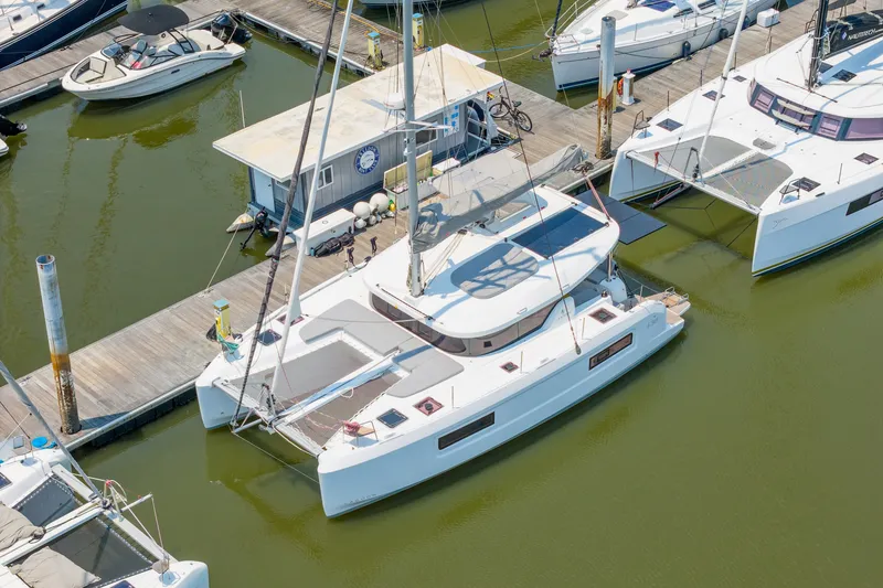 Slide: The Image of 2026 Lagoon 38 catamaran docked at marina, surrounded by other boats. - 85