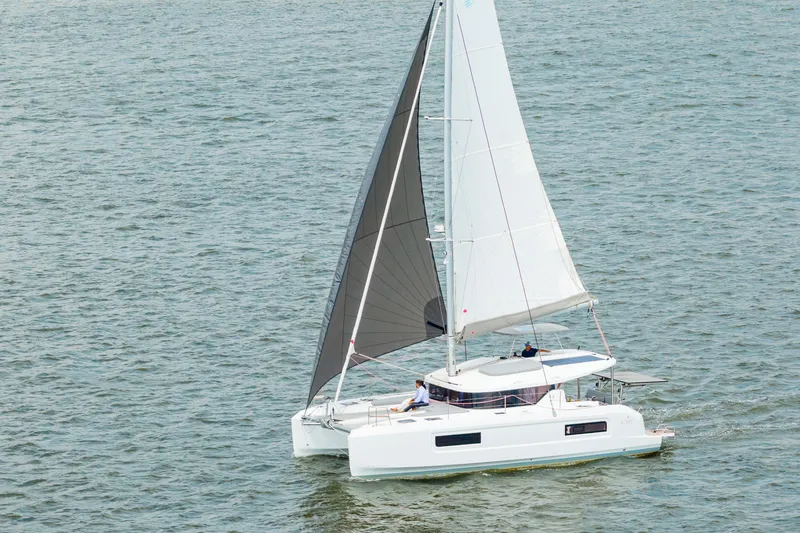 Slide: The Image of 2026 Lagoon 38 catamaran sailing on open water with dual sails. - 98