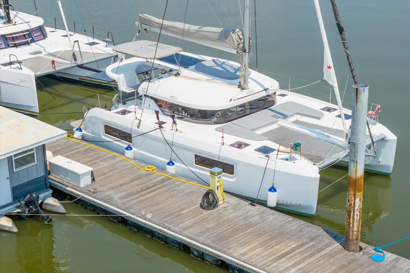 Slide: The Image of Modern 2026 Lagoon 38 catamaran docked at marina, showcasing sleek design and spacious deck. - 84
