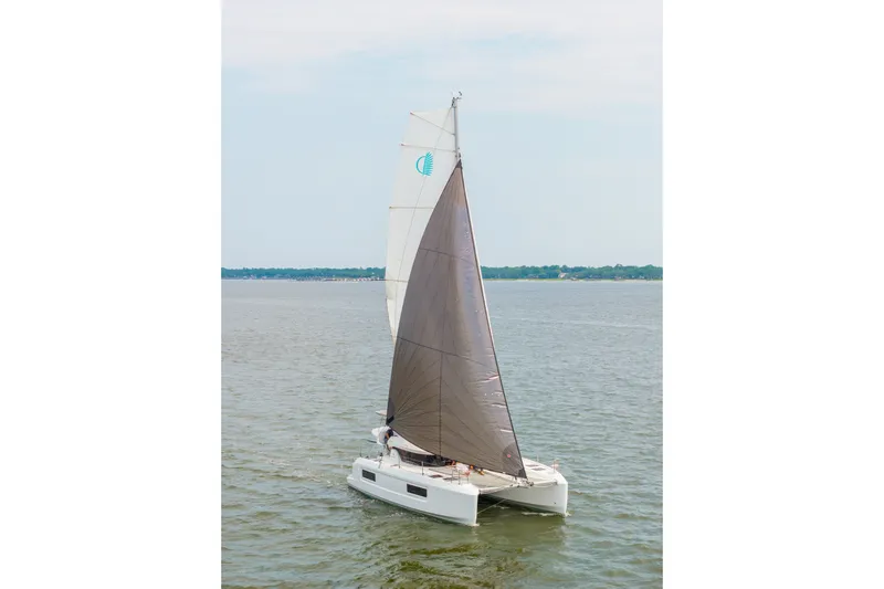 Slide: The Image of 2026 Lagoon 38 catamaran sailing on calm waters under a clear sky. - 97