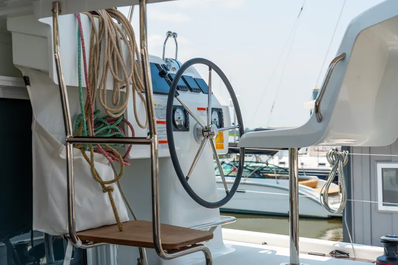 Slide: The Image of Steering wheel and ropes on a 2026 Lagoon 38 catamaran, docked at a marina. - 35