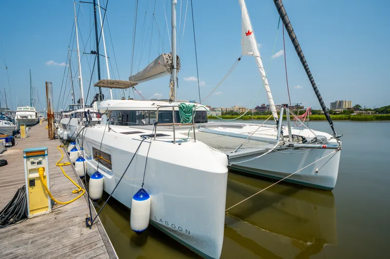 Slide: The Image of Modern 2026 Lagoon 38 catamaran docked at marina under clear blue sky. - 8