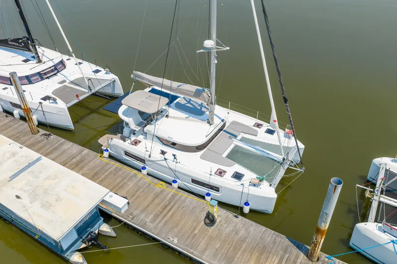 Slide: The Image of 2026 Lagoon 38 catamaran docked at marina, aerial view. - 82