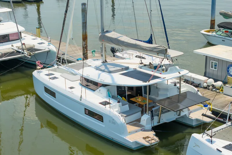 Slide: The Image of 2026 Lagoon 38 catamaran docked at marina, featuring spacious deck and modern design. - 93