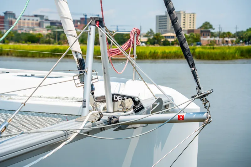 Slide: The Image of 2026 Lagoon 38 catamaran bow with rigging, anchored near urban waterfront. - 23