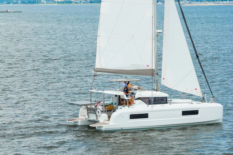 Slide: The Image of 2026 Lagoon 38 catamaran sailing on open water with white sails. - 123