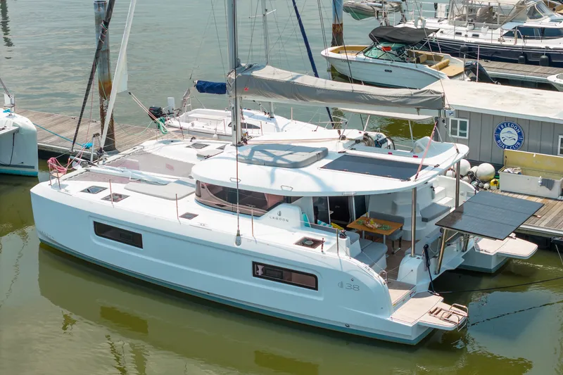 Slide: The Image of 2026 Lagoon 38 catamaran docked at marina, showcasing sleek design and modern features. - 92