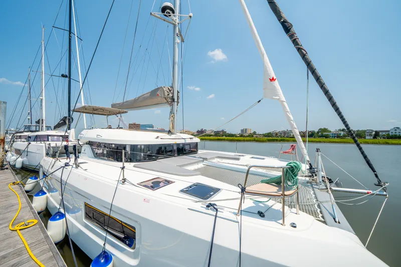 Slide: The Image of Modern 2026 Lagoon 38 catamaran docked, showcasing sleek design and spacious deck. - 9