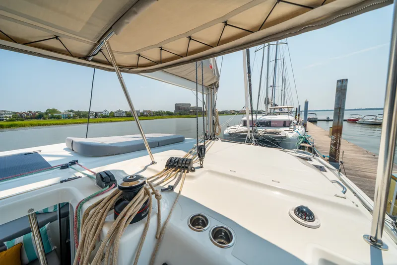 Slide: The Image of 2026 Lagoon 38 catamaran docked at a marina, showcasing deck and rigging. - 11