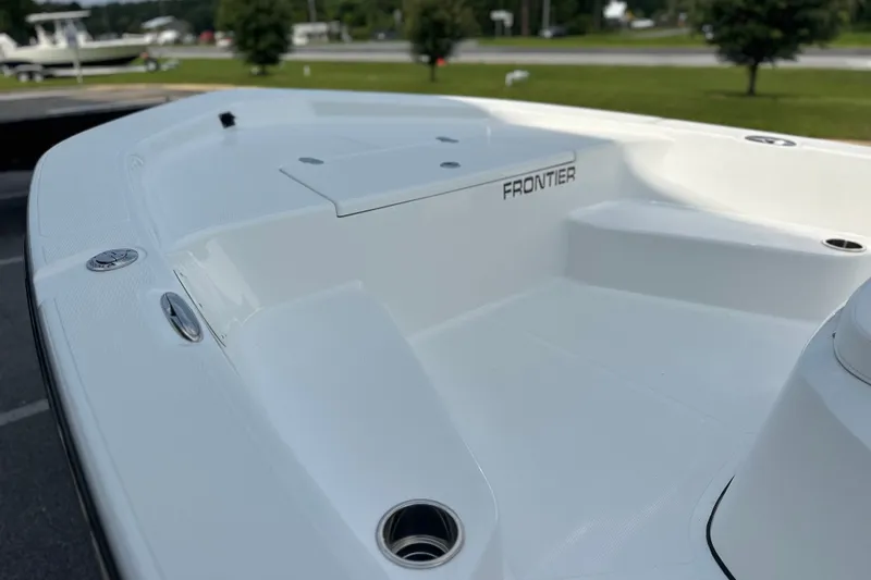 Slide: The Image of 2027 Frontier 180 boat deck, sleek white design with modern features, parked outdoors. - 10