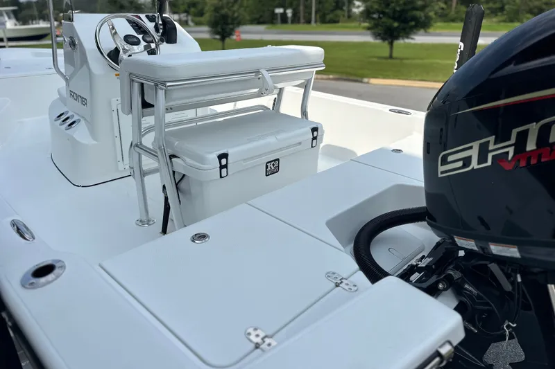 Slide: The Image of 2027 Frontier 180 boat interior with seating, console, and outboard motor. - 14