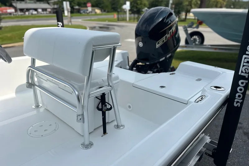 Slide: The Image of 2027 Frontier 180 boat interior with white seating and outboard motor. - 11