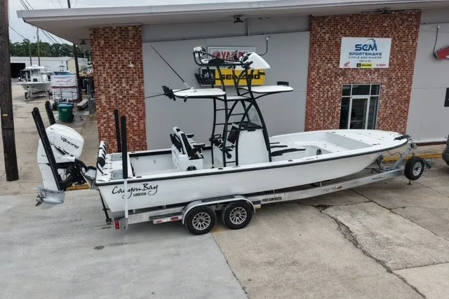 Slide: The Image of 2023 Canyon Bay 28h boat on trailer outside a brick building. - 1
