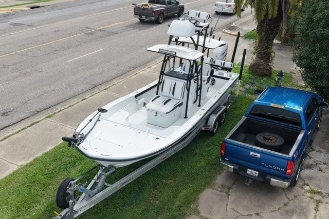 Slide: The Image of 2023 Canyon Bay 28h boat on trailer beside blue pickup truck. - 6