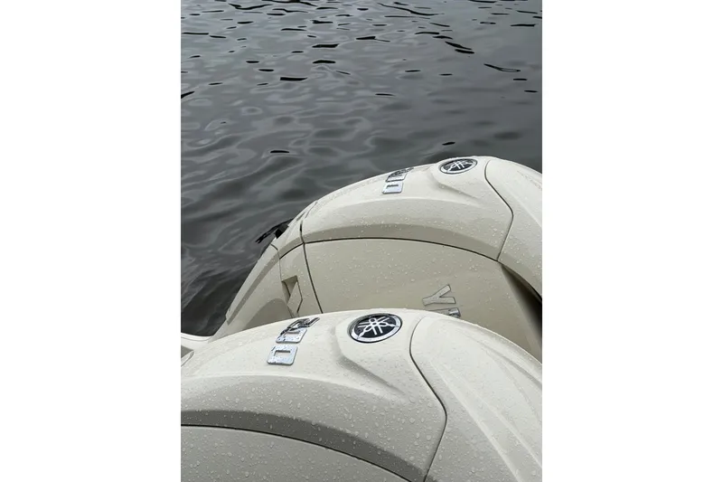 Slide: The Image of Twin Yamaha outboard engines on a 2025 Grady-White Freedom 275 boat, near water. - 12